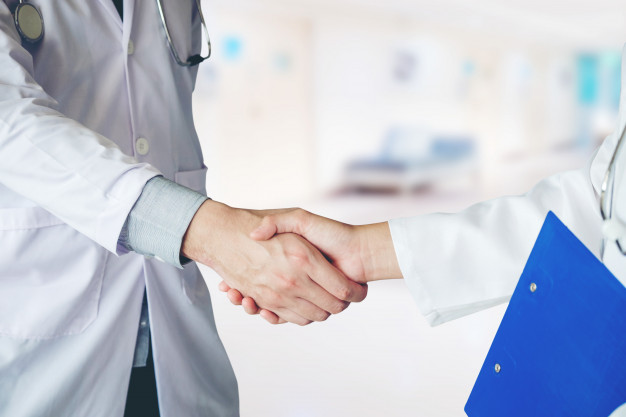 A Medical Surgeon Shaking Hands With Her Franchising Partner.